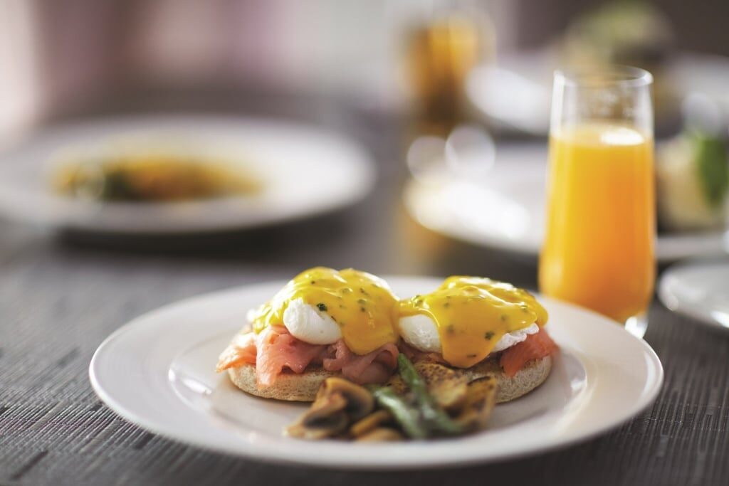 Plate of Eggs Benedict with juice